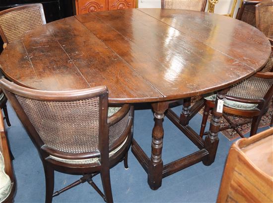 A 17th century style oak oval topped gateleg dining table L.177cm